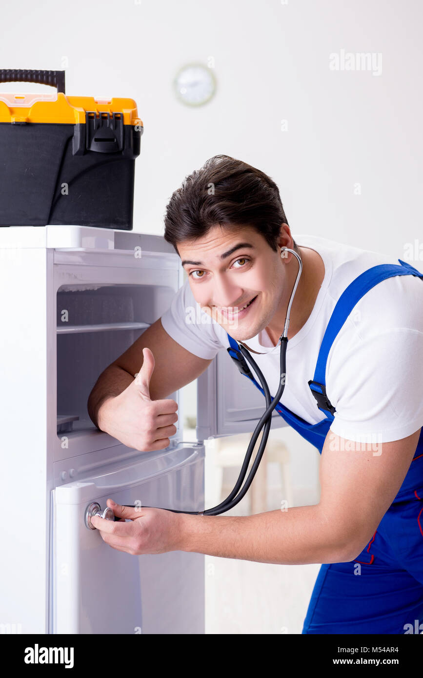 Repairman contractor repairing fridge in DIY concept Stock Photo Alamy