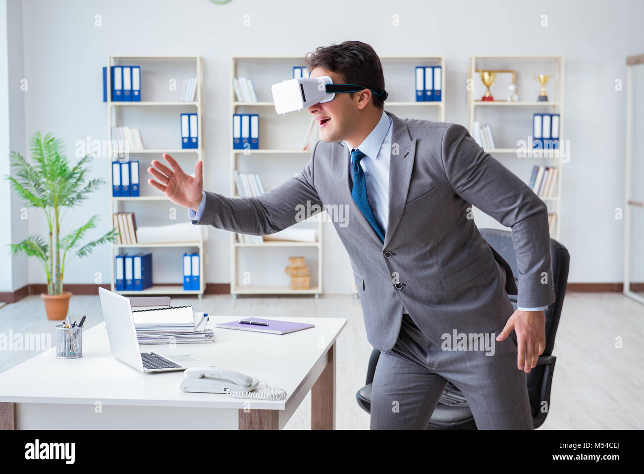 Businessman exercising in office wearing VR glasses Stock Photo - Alamy