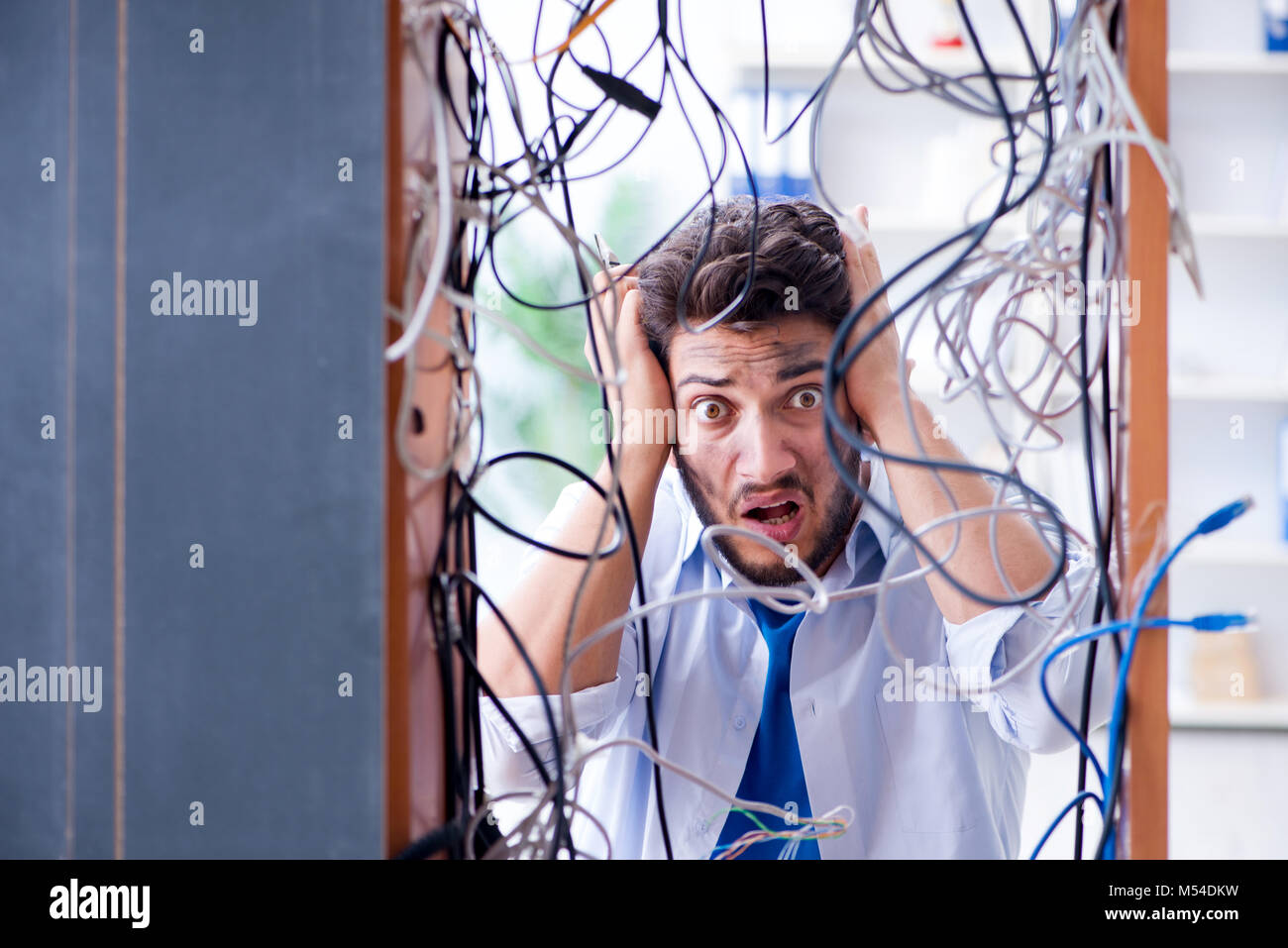 Electrician trying to untangle wires in repair concept Stock Photo Alamy