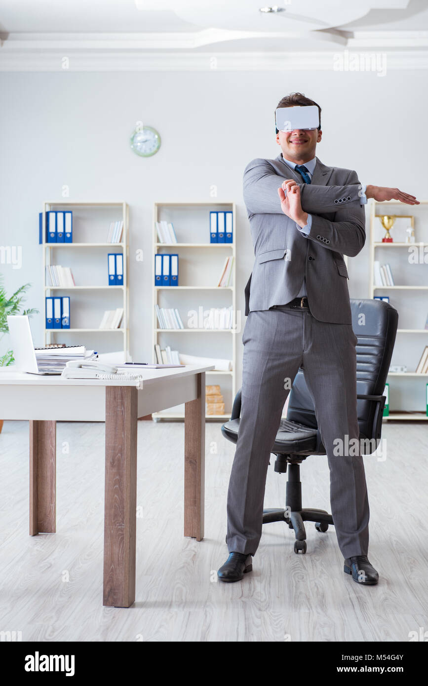 Businessman exercising in office wearing VR glasses Stock Photo - Alamy
