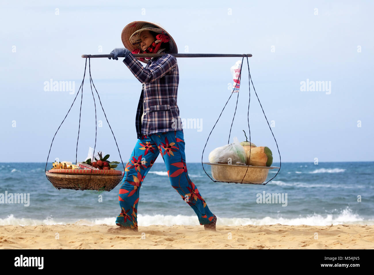 Asian woman is selling fruits on beach Stock Photo