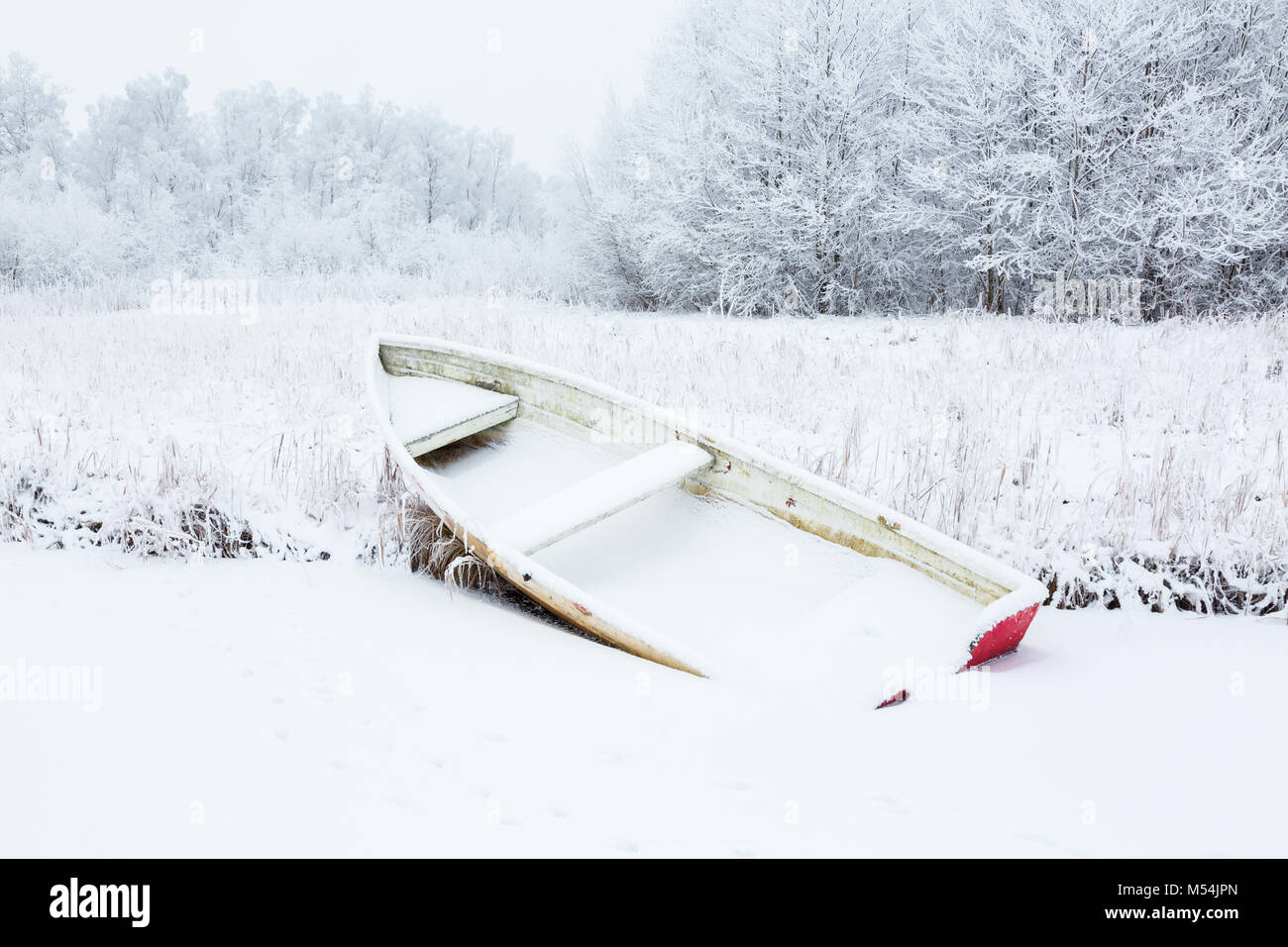 Rowing boat on the beach in snowy scenes Stock Photo