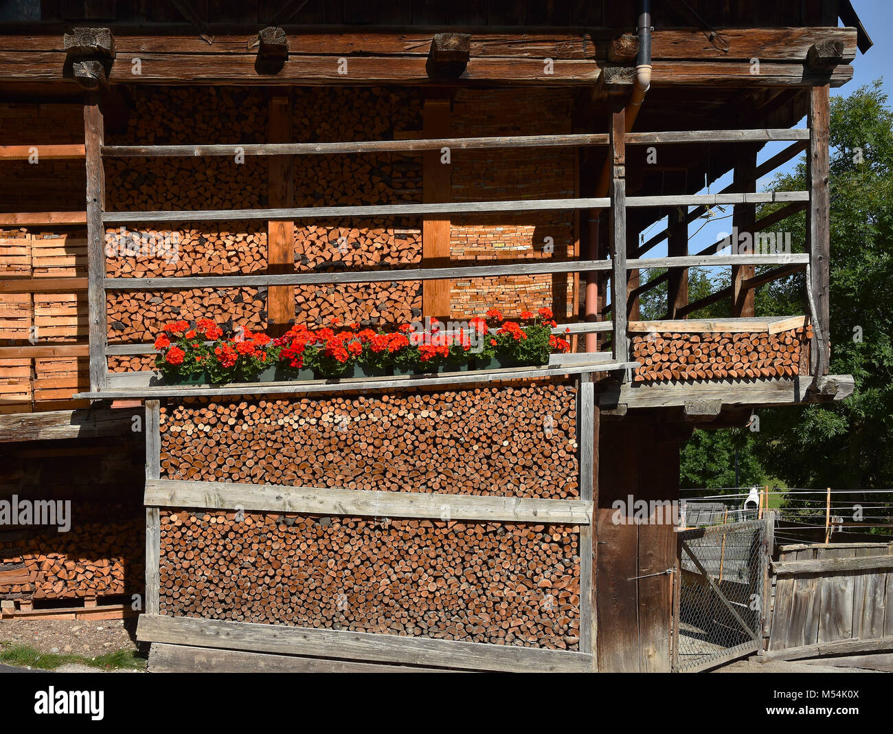 timber house; stacked firewood; wooden pile; dolomite alps; Italy
