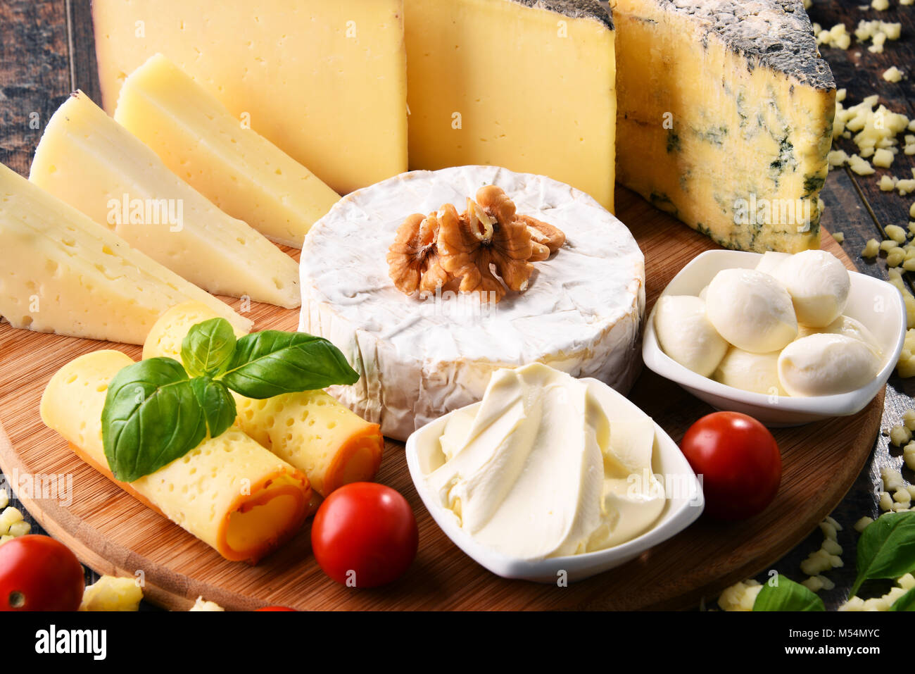 Different sorts of cheese on kitchen table Stock Photo - Alamy