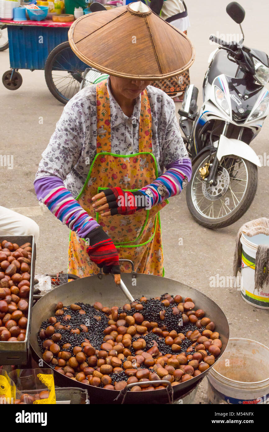 thai woman preparing roasted chestnuts on the street Stock Photo