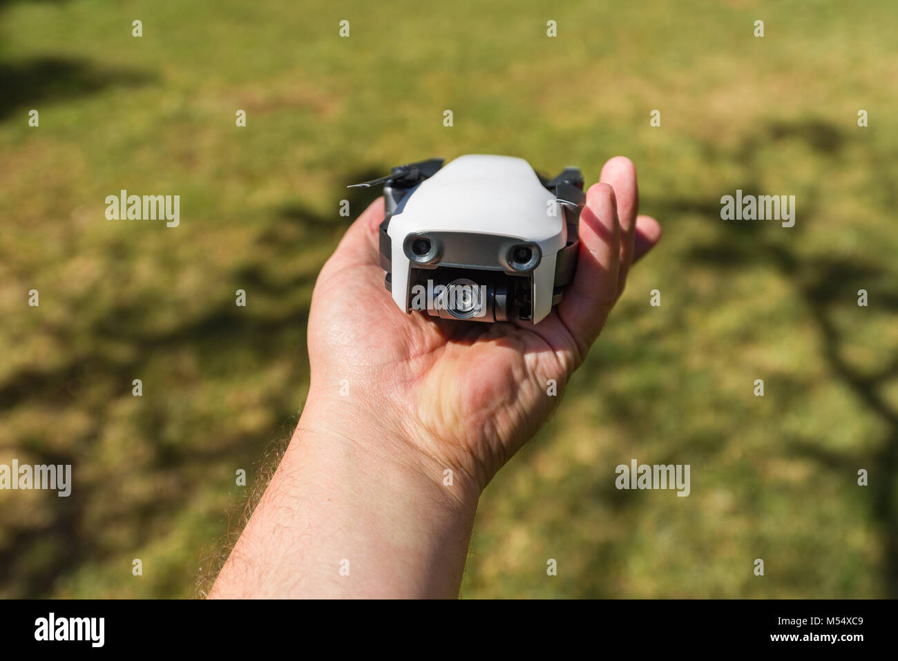 A DJI Mavic Air drone folded in a mans hand to show the size of