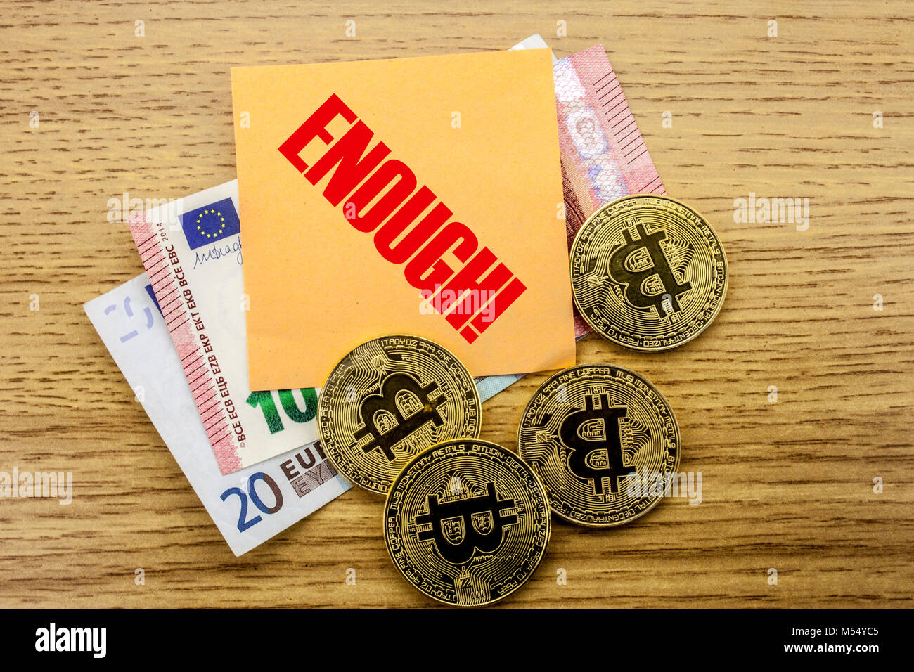 Bitcoins, Bit Coin on Euro, Dollars notes witch sticky note on wooden background, ENOUGH bitcoin concept. Stock Photo