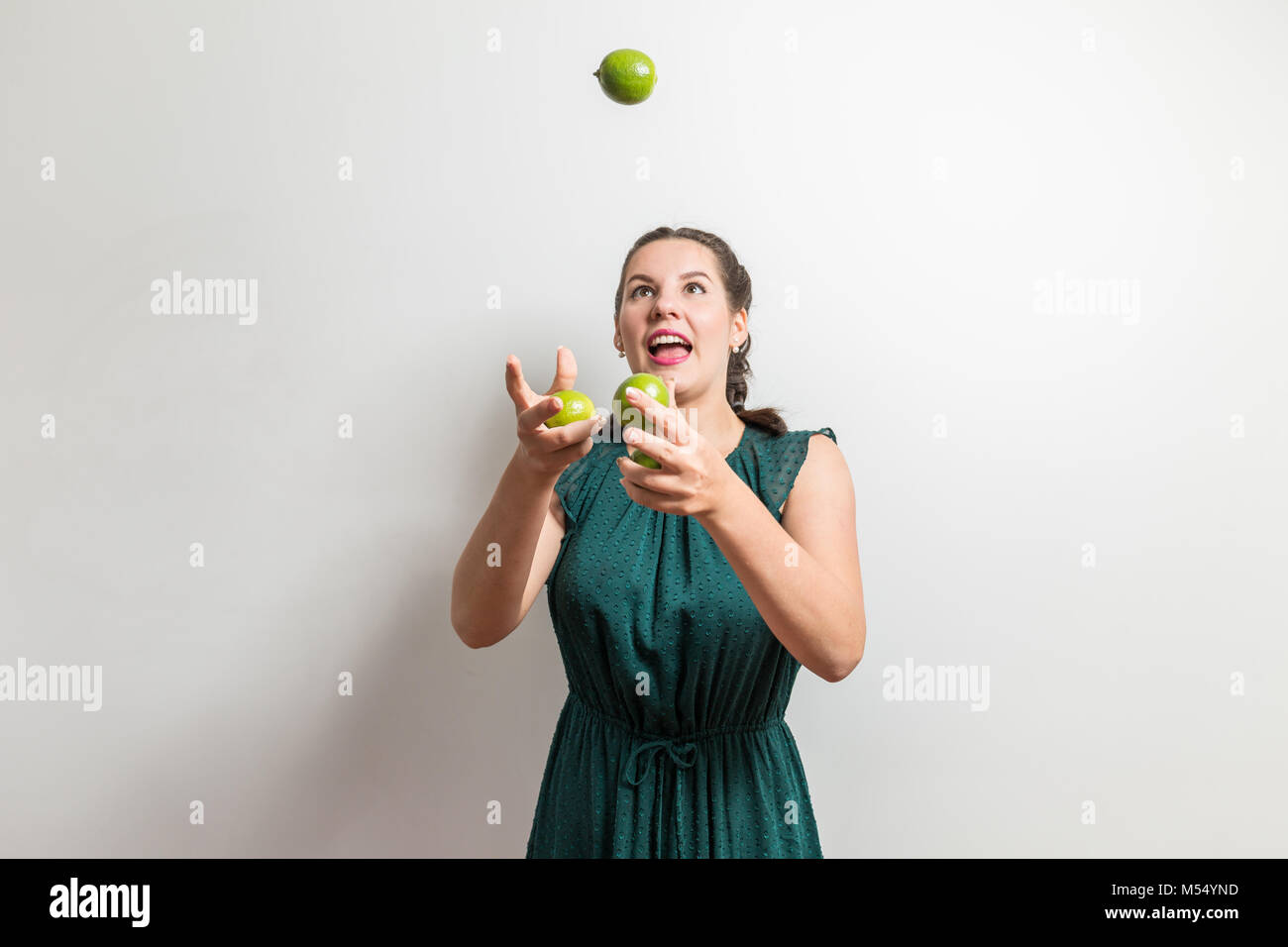 Funny girl tries to juggle with fruits Stock Photo Alamy