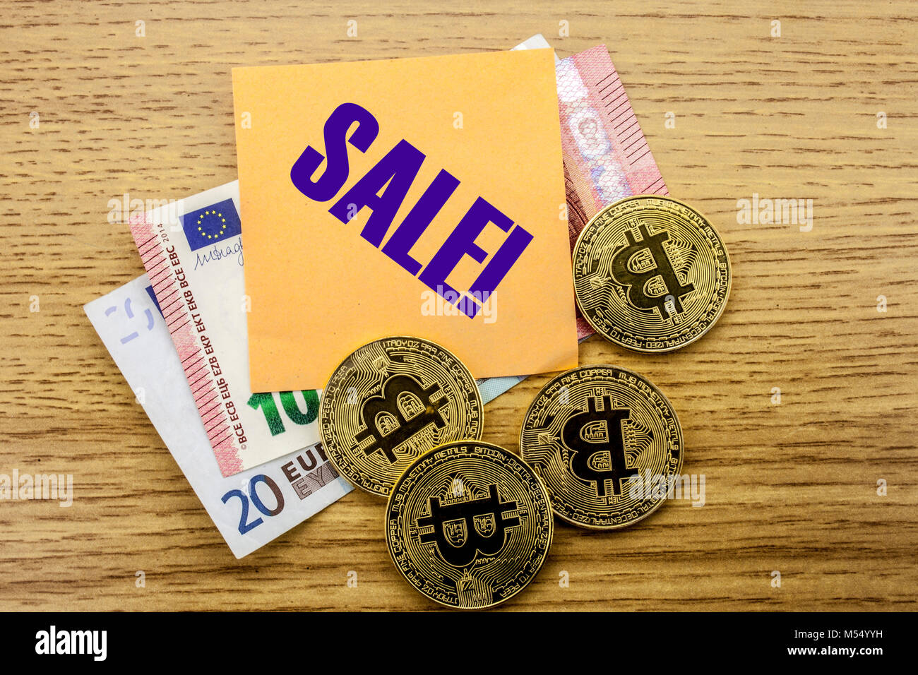 Bitcoins, Bit Coin on Euro, Dollars notes witch sticky note on wooden background, SALE bitcoin concept. Stock Photo