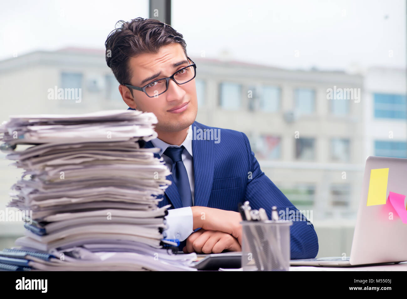The workaholic businessman overworked with too much work in office ...
