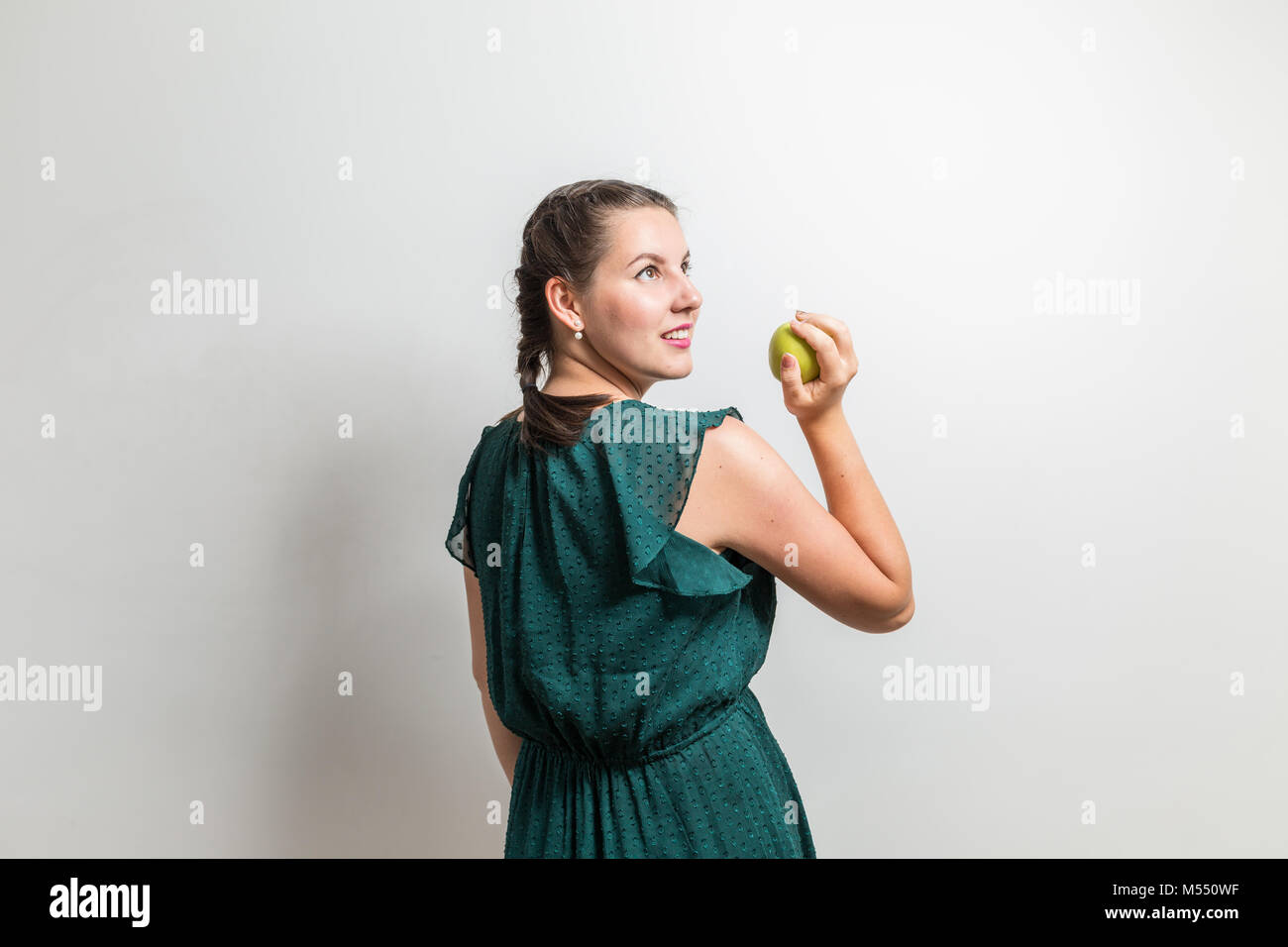 Young model looks to side and holds fruit in hand-Edit Stock Photo