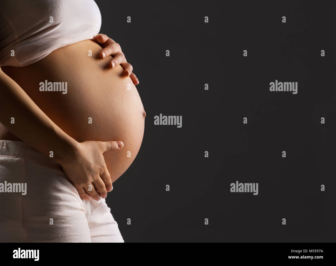 Pregnant woman caressing her belly Stock Photo