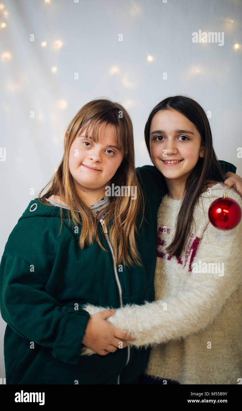 portrait of 10-year-old friends, one with down syndrome, hugging each other smiling Stock Photo