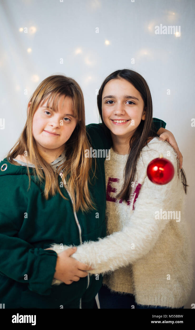 portrait of 10-year-old friends, one with down syndrome, hugging each other smiling Stock Photo