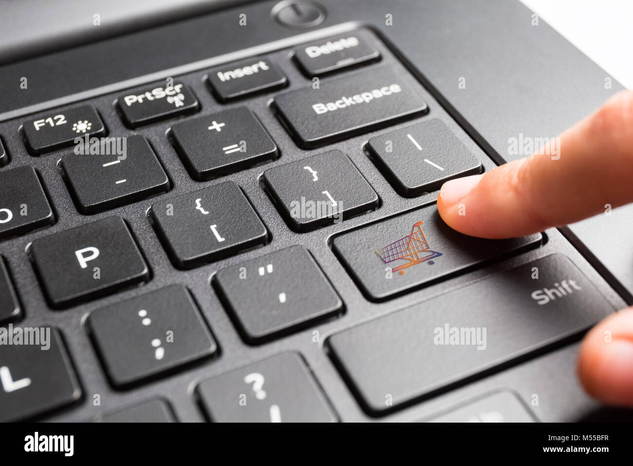 laptop keyboard with finger pressing shopping cart key Stock Photo