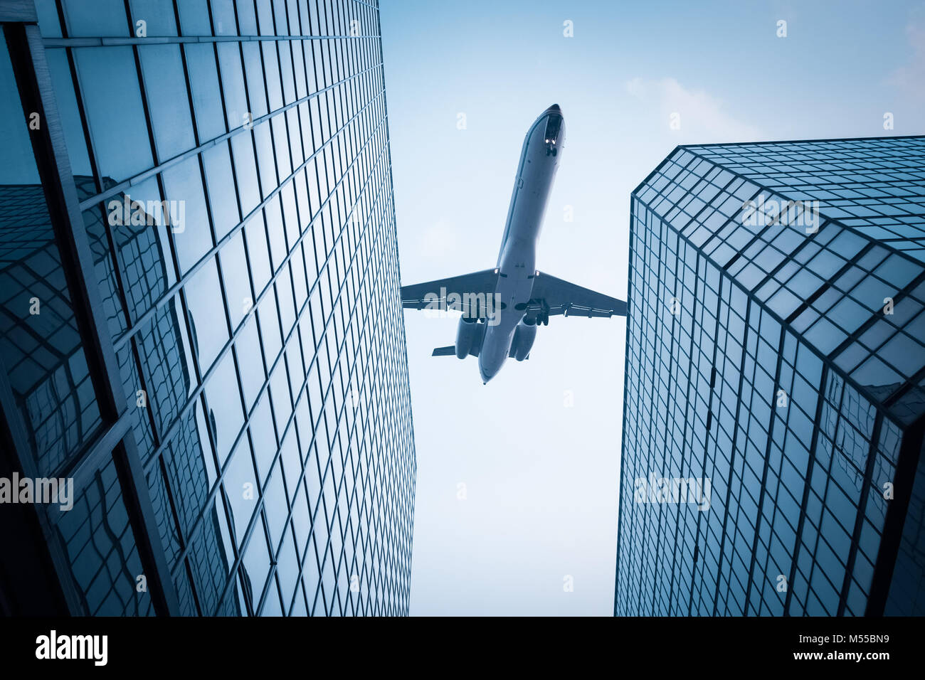 airplane above modern building Stock Photo