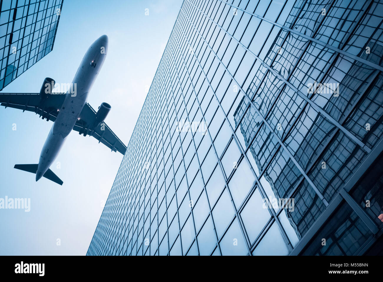 airplane above modern building Stock Photo