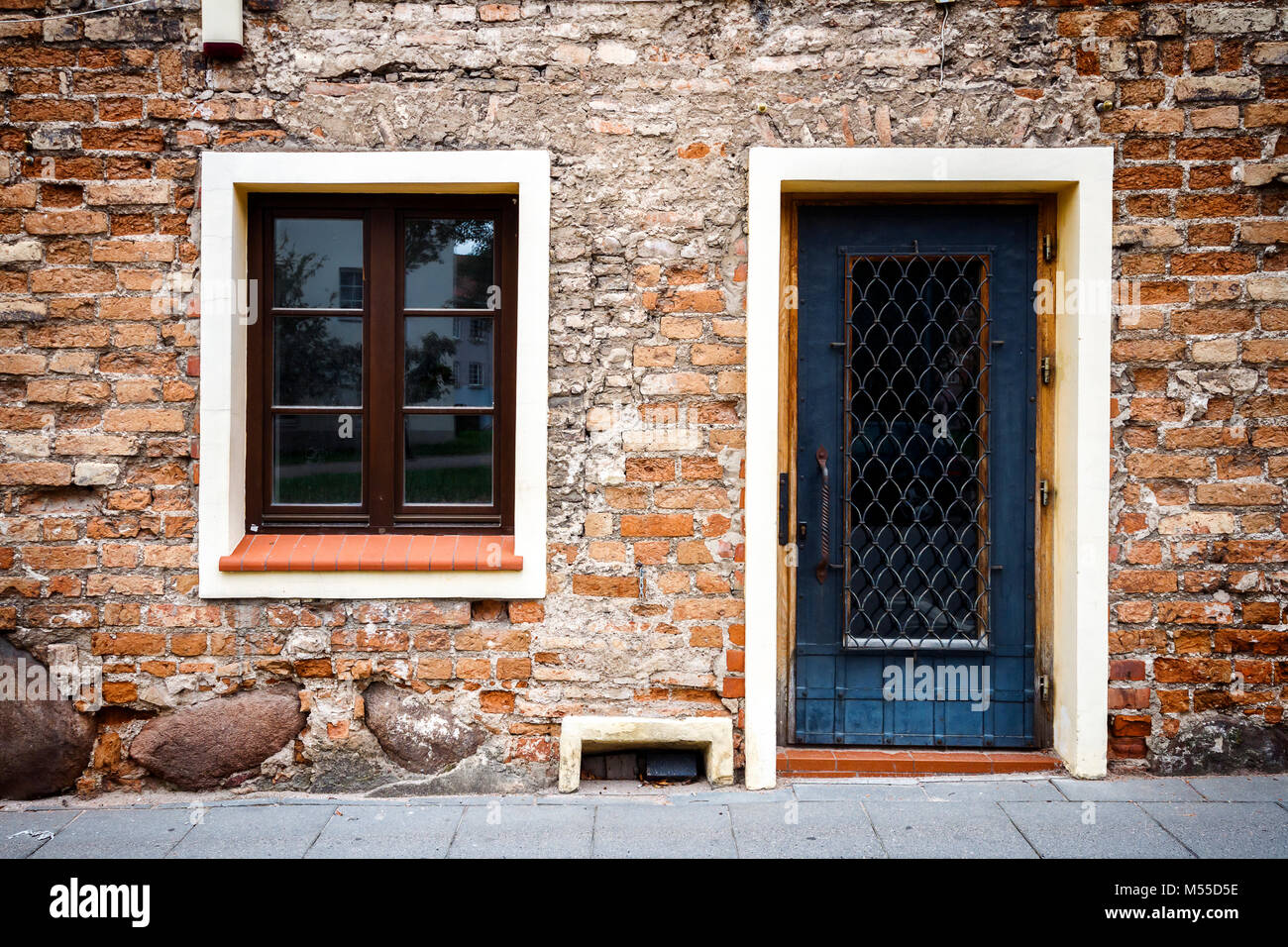 Old weathered street wall with a window and door Stock Photo - Alamy