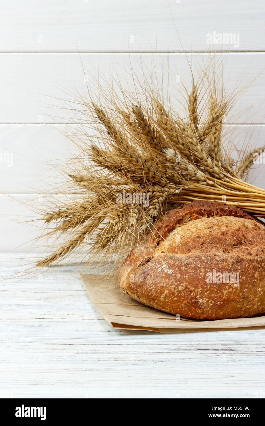 Bread and wheat on white wooden background Stock Photo - Alamy