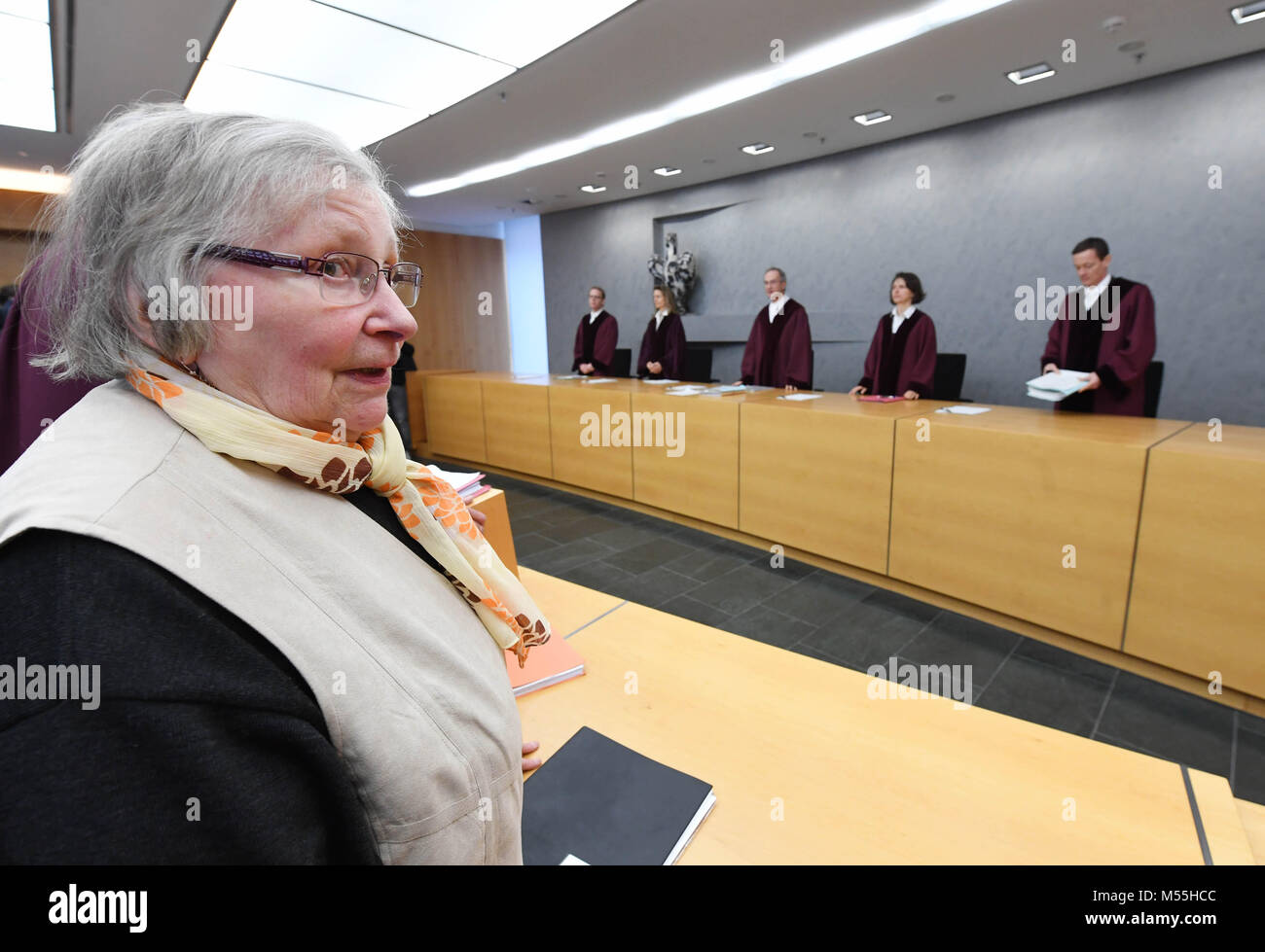 20 February 2018, Germany, Karlsruhe: Marlies Kraemer waits for the beginning of her trial at the Federal Supreme Court (BGH). The sixth civil senate stands in the background: Oliver Klein (L-R), Vera von Pentz, Gregor Galke, Stefanie Roloff und Peter Allgayer. The pensioner filed a lawsuit that Sparkasse is to name the female term of 'Kontoinhaber' (lit. account holder), being 'Kontoinhaberin' on their forms. Photo: Uli Deck/dpa Stock Photo