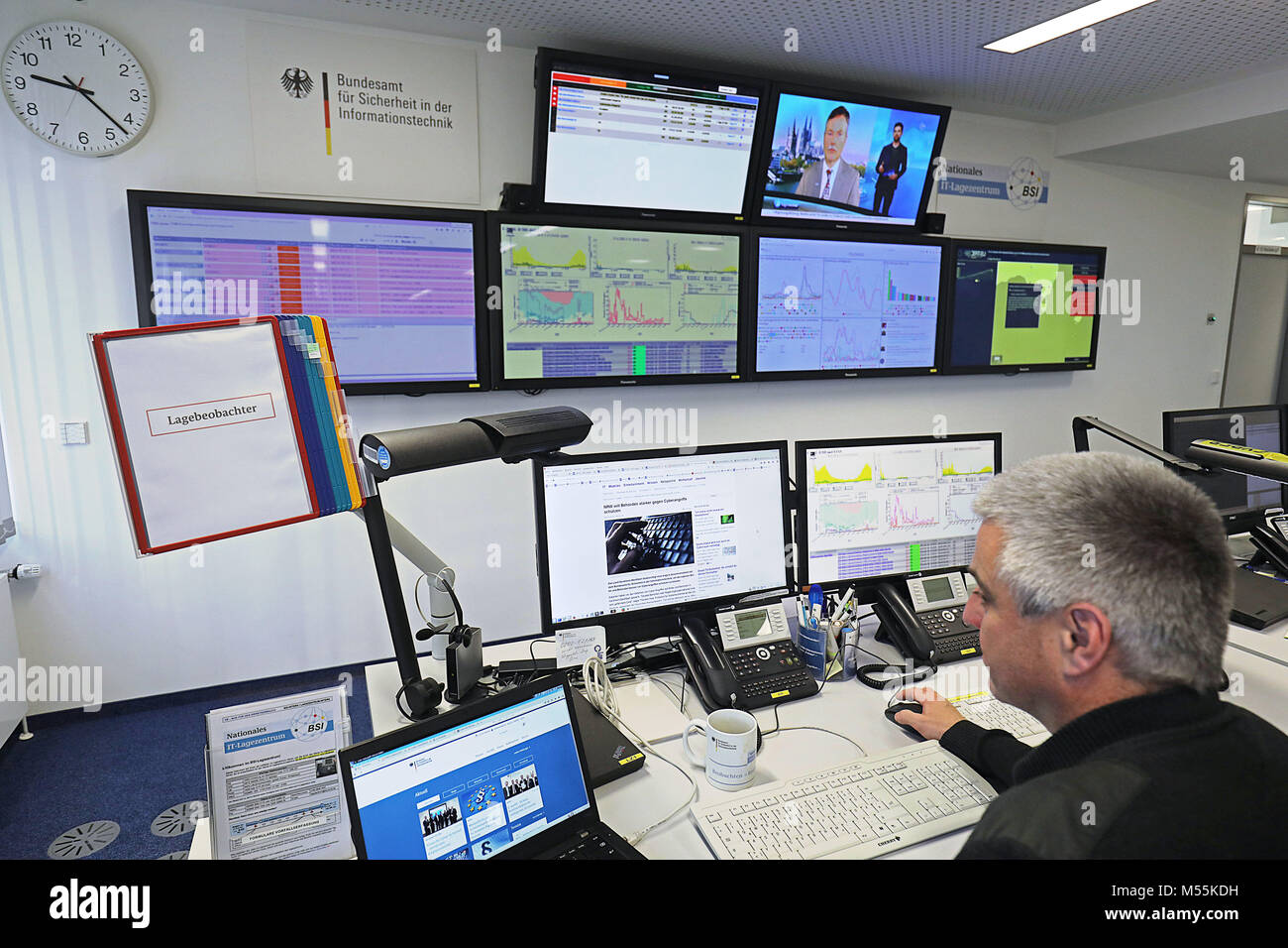 20 February 2018, Germany, Bonn: An employee of the Bundesamt für Sicherheit in der Informationstechnik (BSI) (Federal Office for Information Security) sits in front of screens in the national IT centre. North Rhine-Westphalia is to be better protected against cyber attacks. The state, therefore, wants to work more closely with the Federal Office for Information Security. Photo: Oliver Berg/dpa Stock Photo