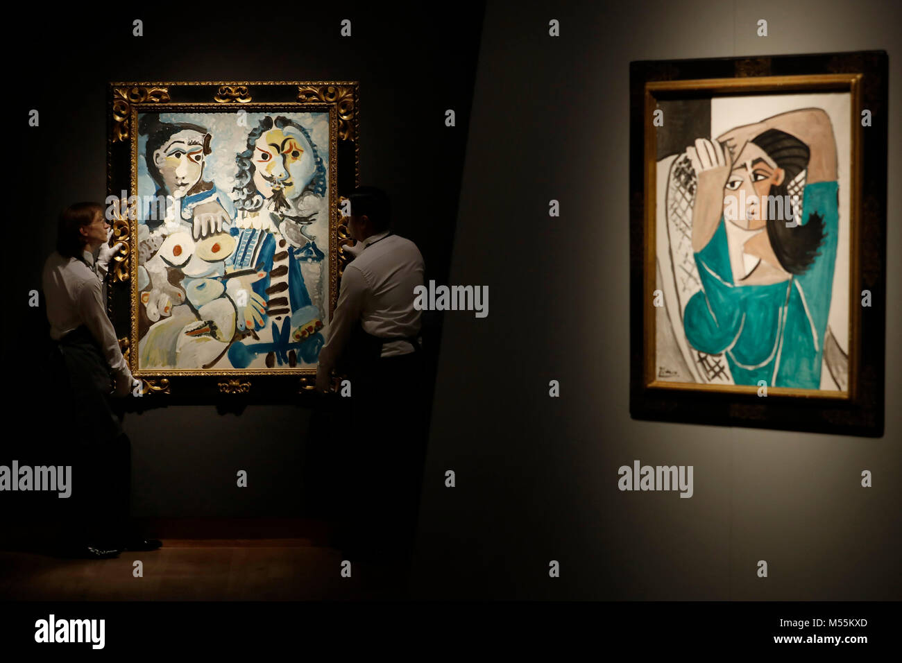 London, UK. 20th February, 2018. Employees pose with paintings (L)  "Mousquetaire at nu assis" and "Femme se coiffant" by artist Pablo Picasso  at Christie's auction house in London Tuesday February 20, 2018.