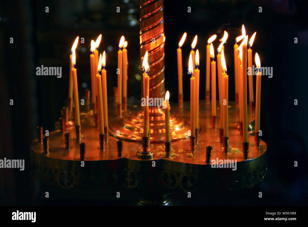 burning church candles on candlesticks in church Stock Photo - Alamy
