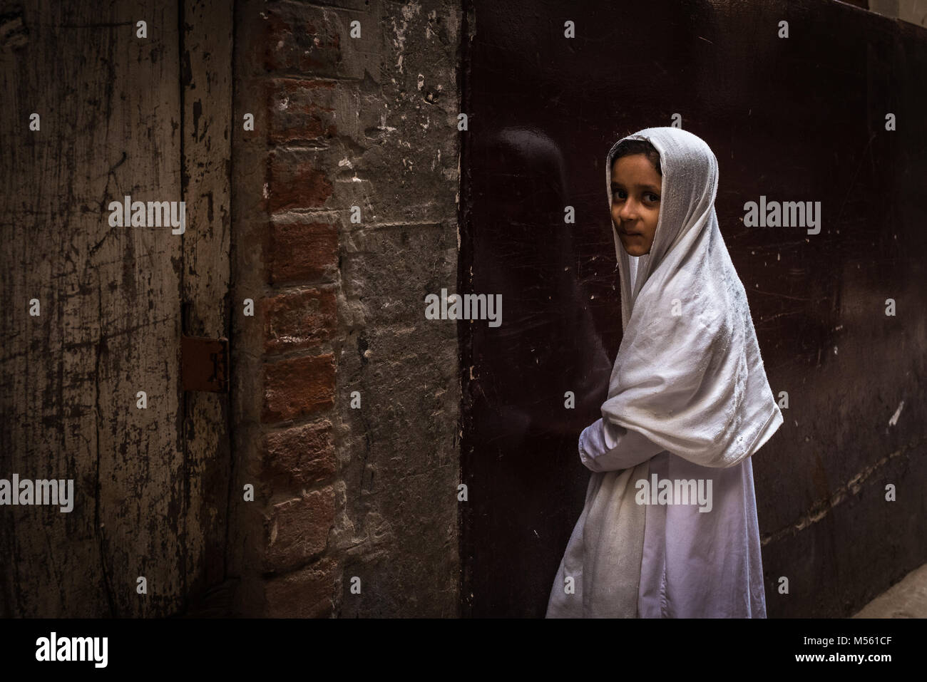Shy Muslim girl standing in an alley, Varanasi, India Stock Photo