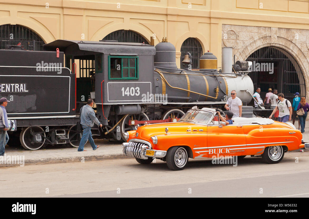 a typical Cuban cabriolet and old steam train Stock Photo