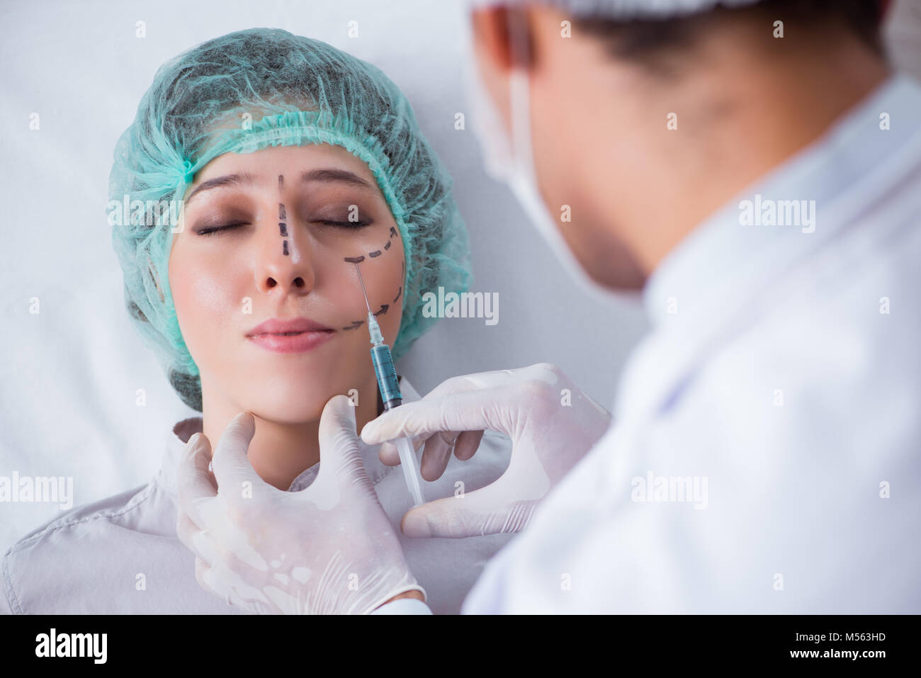 Plastic surgeon preparing for operation on woman face Stock Photo - Alamy