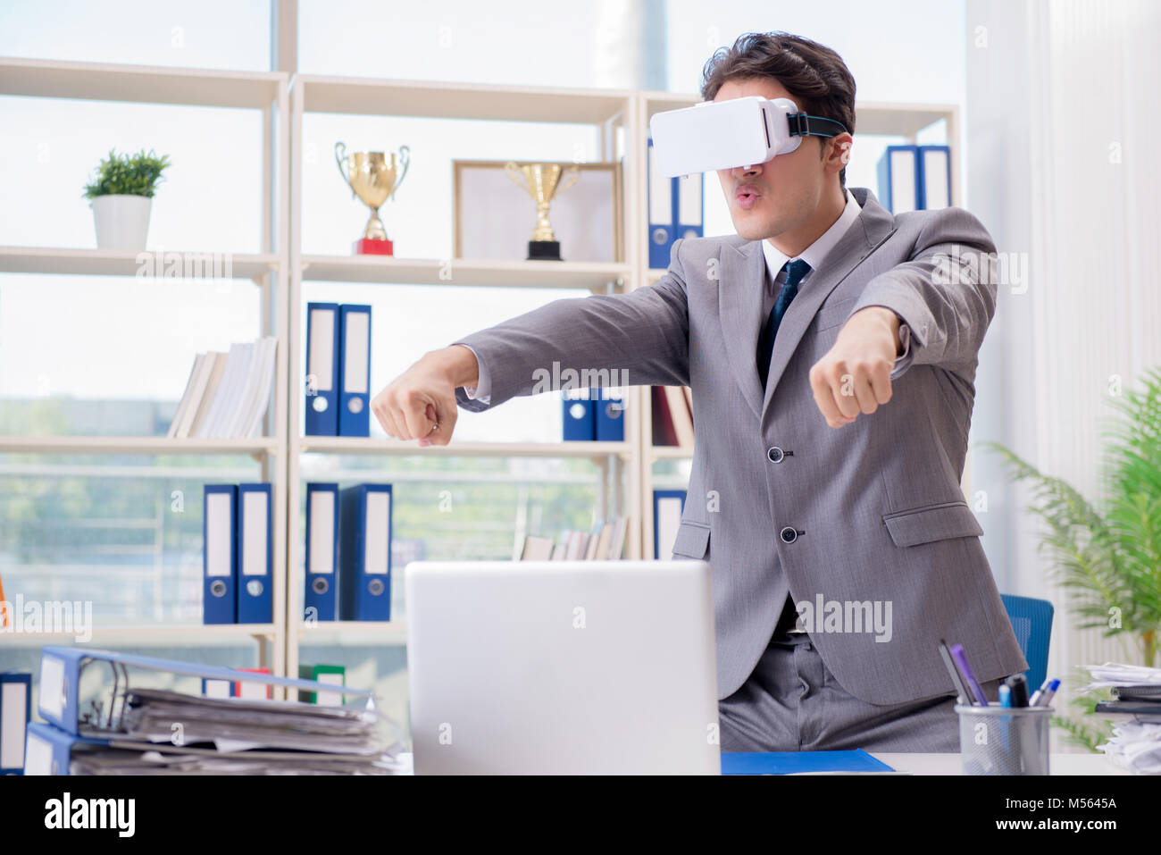 Businessman with VR virtual reality glasses in office Stock Photo - Alamy