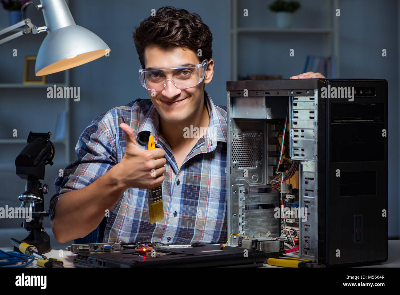 Computer repair man cleaning dust with brush Stock Photo - Alamy