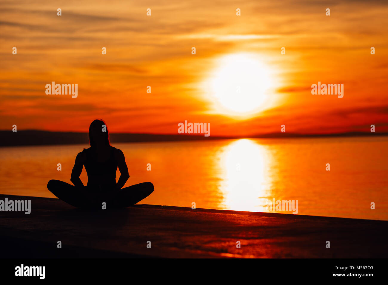 Carefree calm woman meditating in nature.Finding inner peace.Yoga practice.Spiritual healing lifestyle.Enjoying peace,anti-stress therapy,mindfulness  Stock Photo