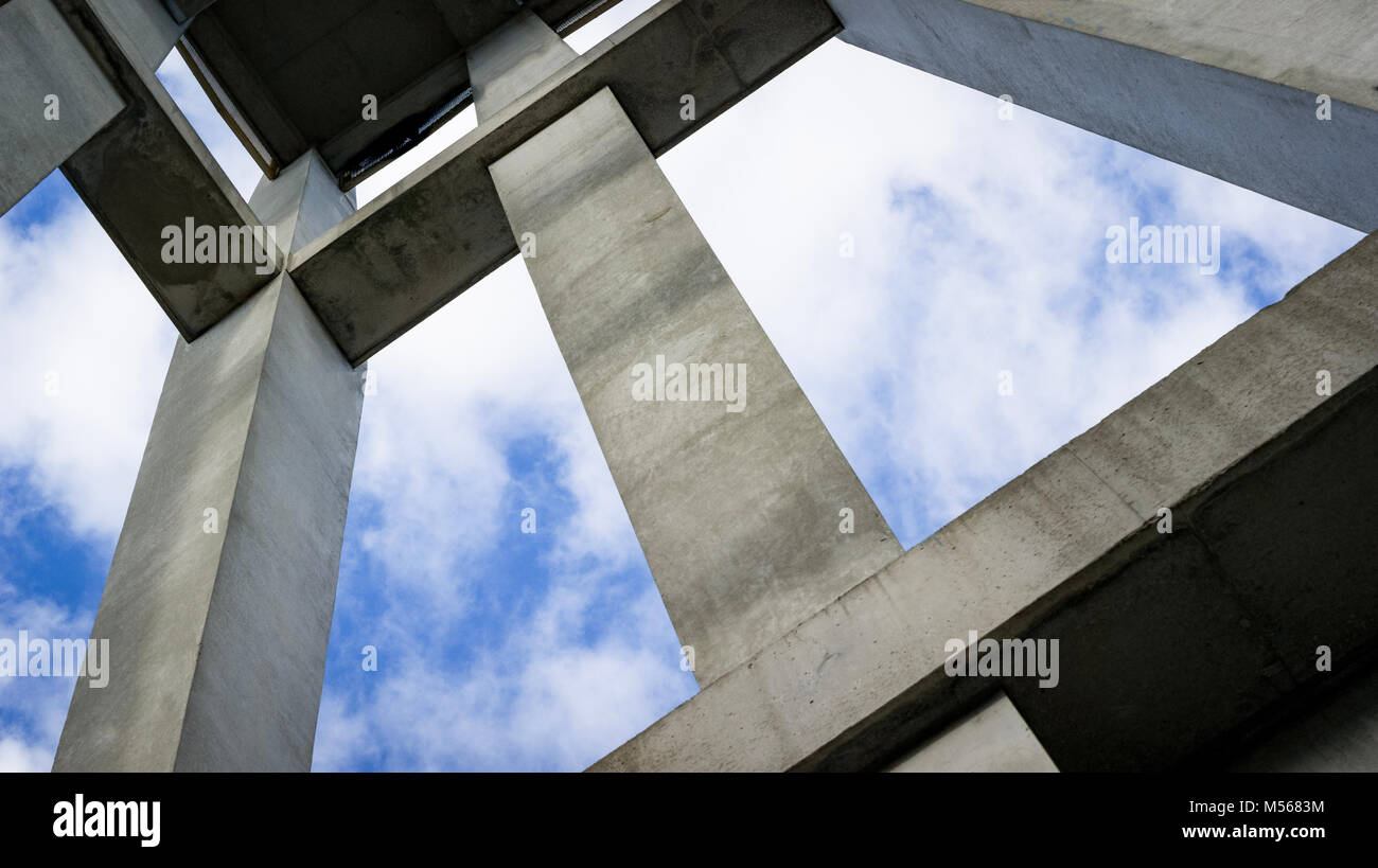 A concrete structure from a worms-eye view against a blue sky with wispy clouds. Stock Photo
