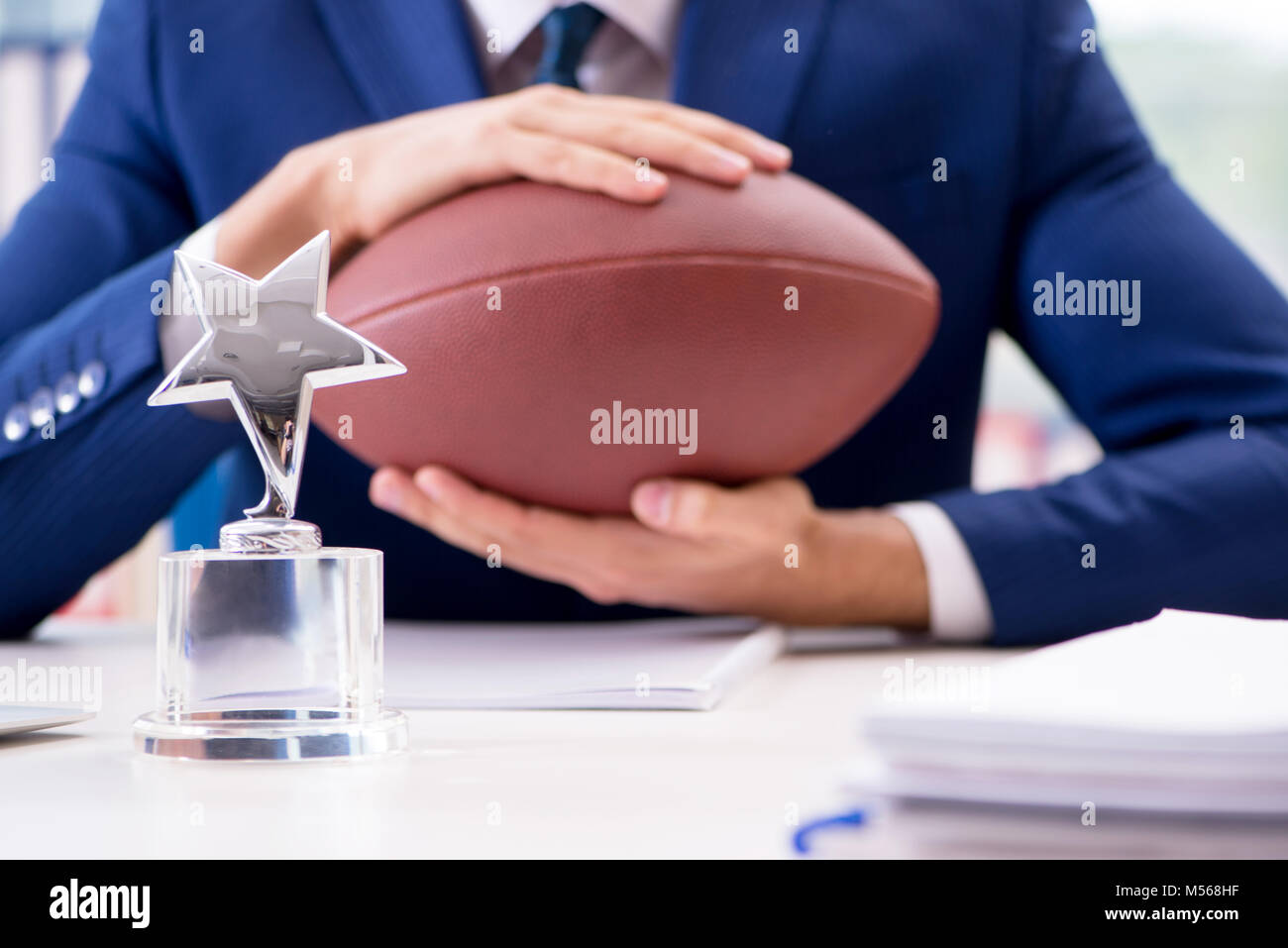 Businessman with american football in office Stock Photo
