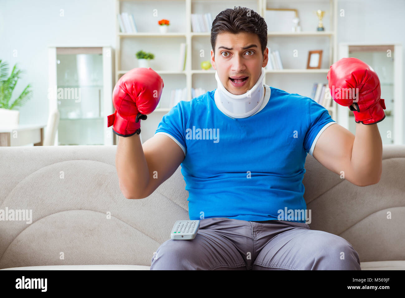 Man with neck injury watching boxing at home Stock Photo Alamy