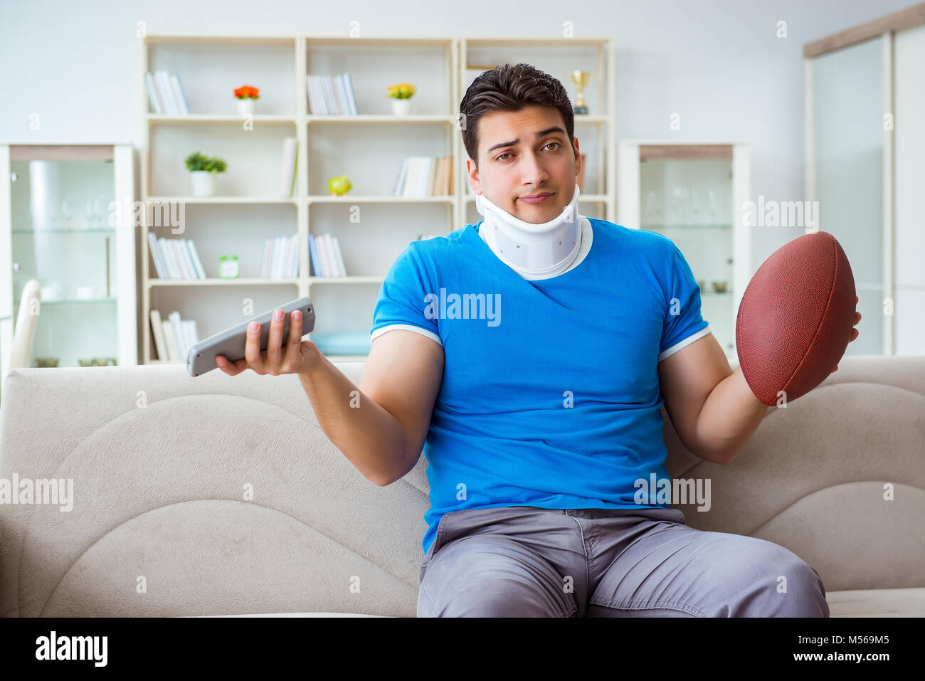 Man with neck injury watching american football at home Stock Photo Alamy