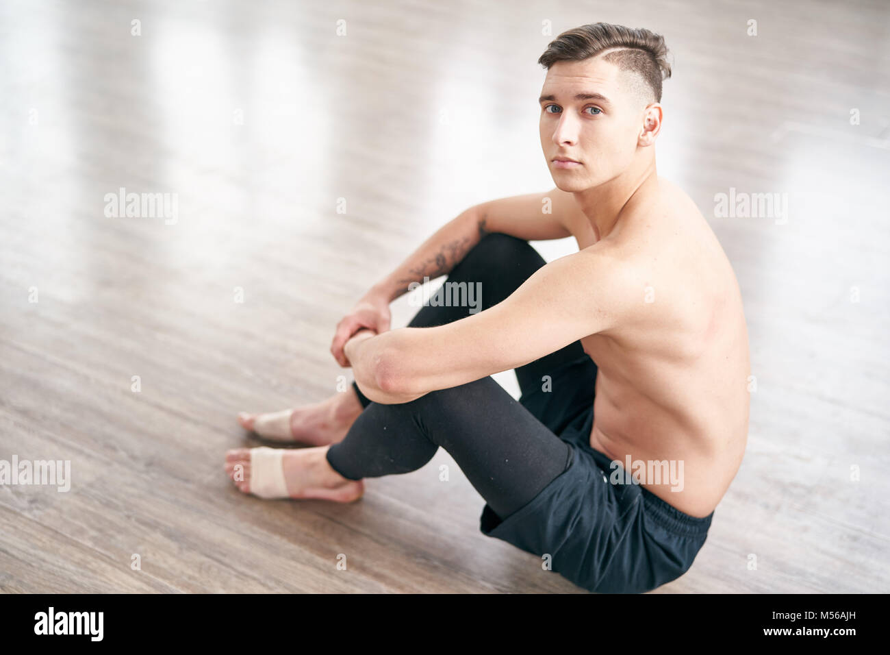 Handsome ballet dancer sitting on the floor and resting Stock Photo Alamy