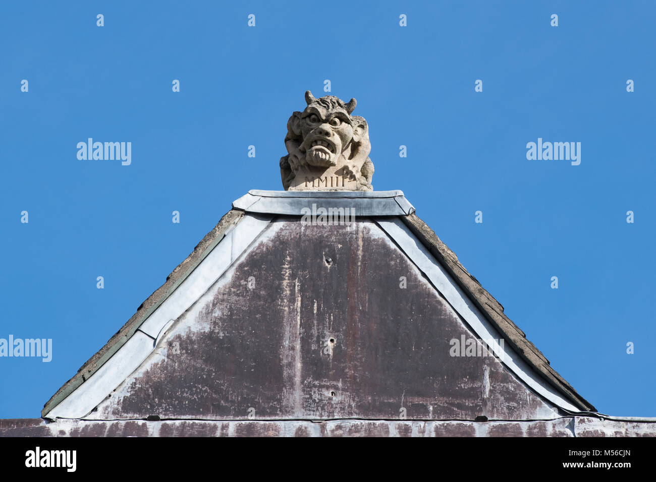 Carved stone horned gargoyle / grotesque on the roof of Lincoln college. Oxford, Oxfordshire, England Stock Photo