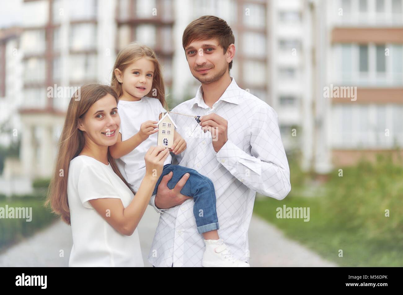 Happy family in front of new apartment building Stock Photo