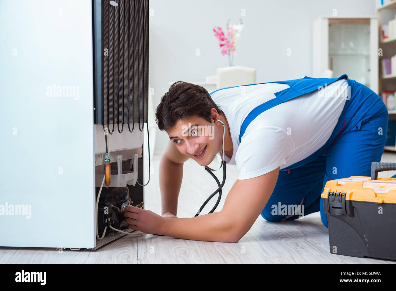 Repairman contractor repairing fridge in DIY concept Stock Photo Alamy