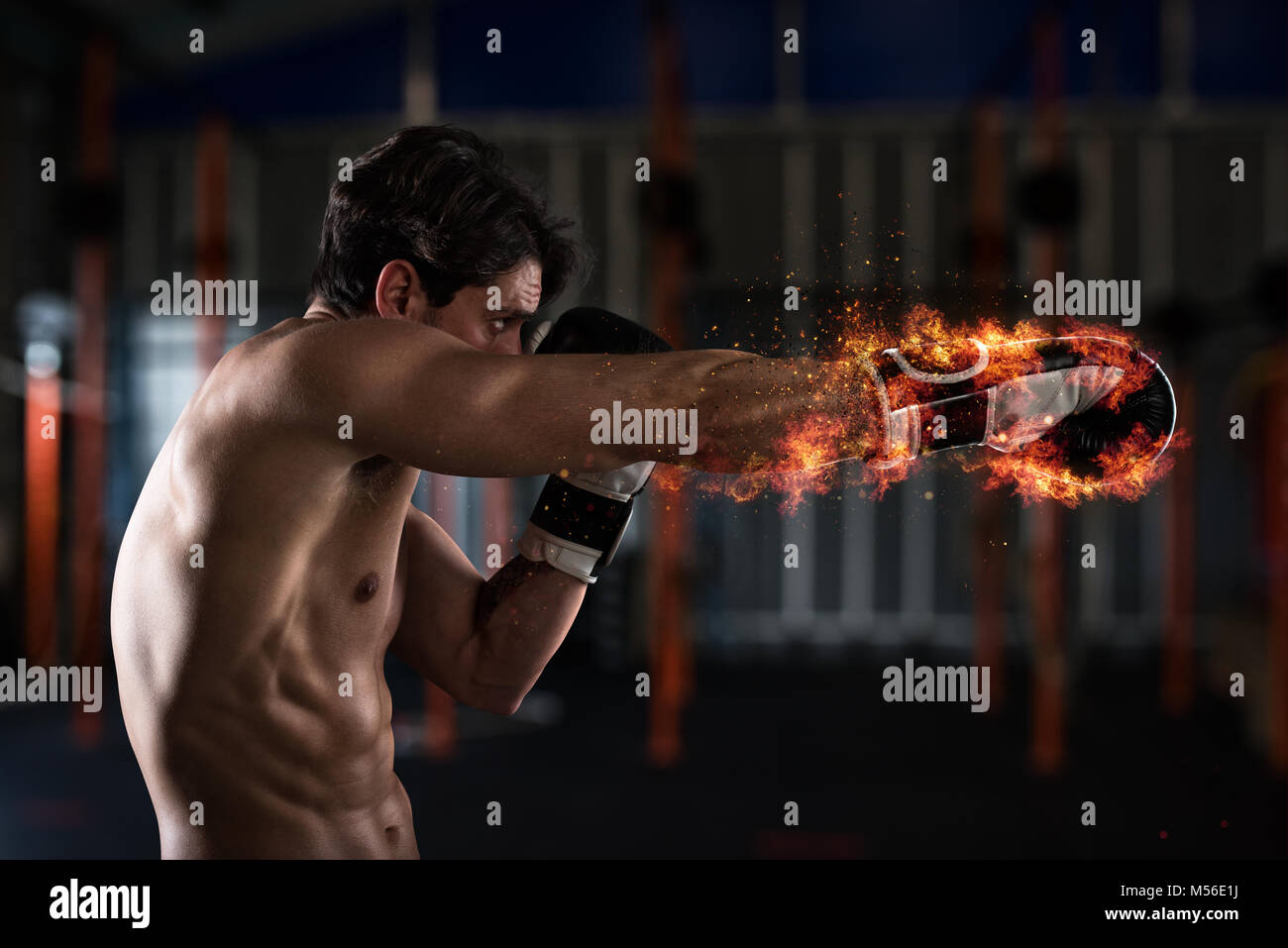 Confident boxer with fiery boxing gloves Stock Photo