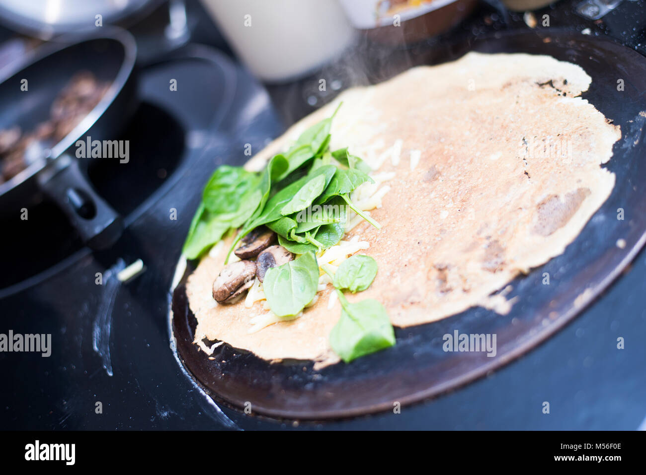 Pancake being cooked on hotplate on Aga style oven Stock Photo