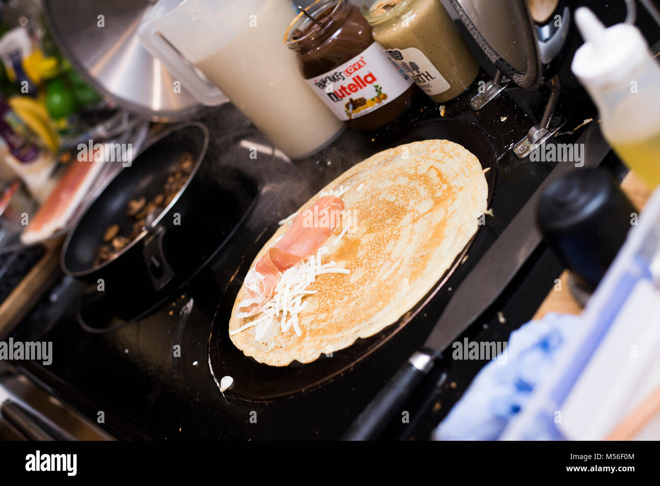 Pancake being cooked on hotplate on Aga style oven Stock Photo Alamy