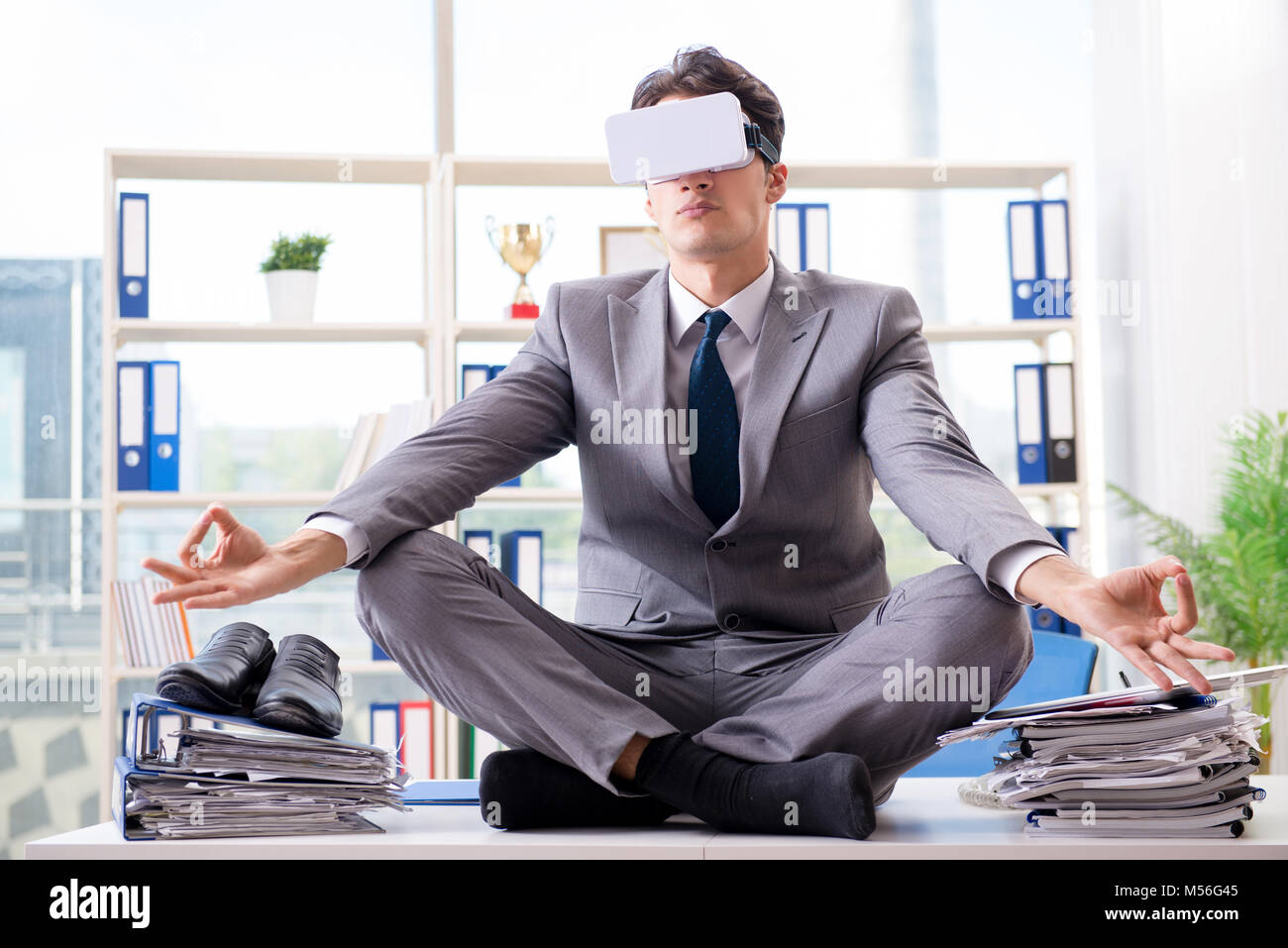 Businessman with VR virtual reality glasses in office Stock Photo - Alamy