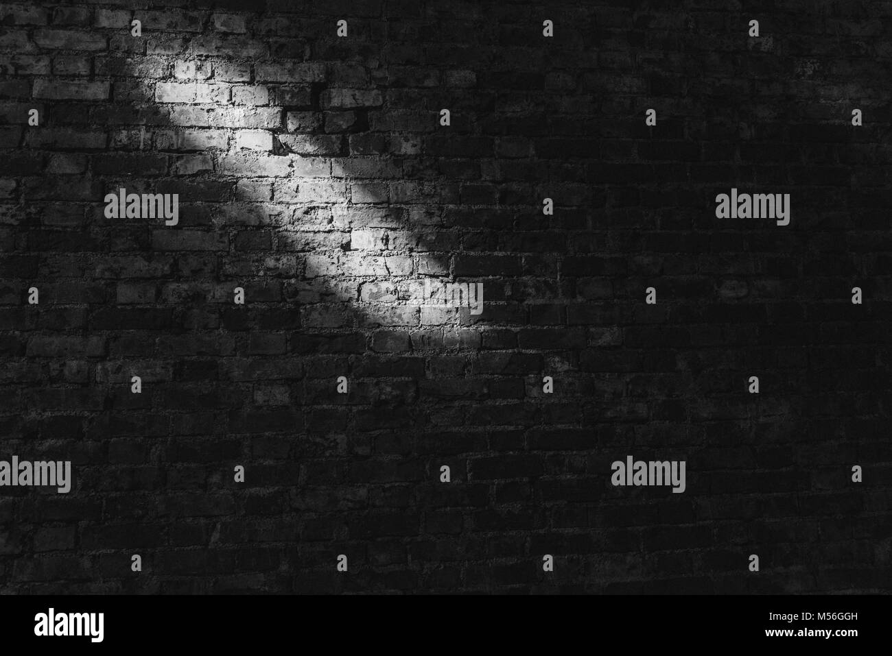 Clay brick wall with light streak on wall pattern, black and white