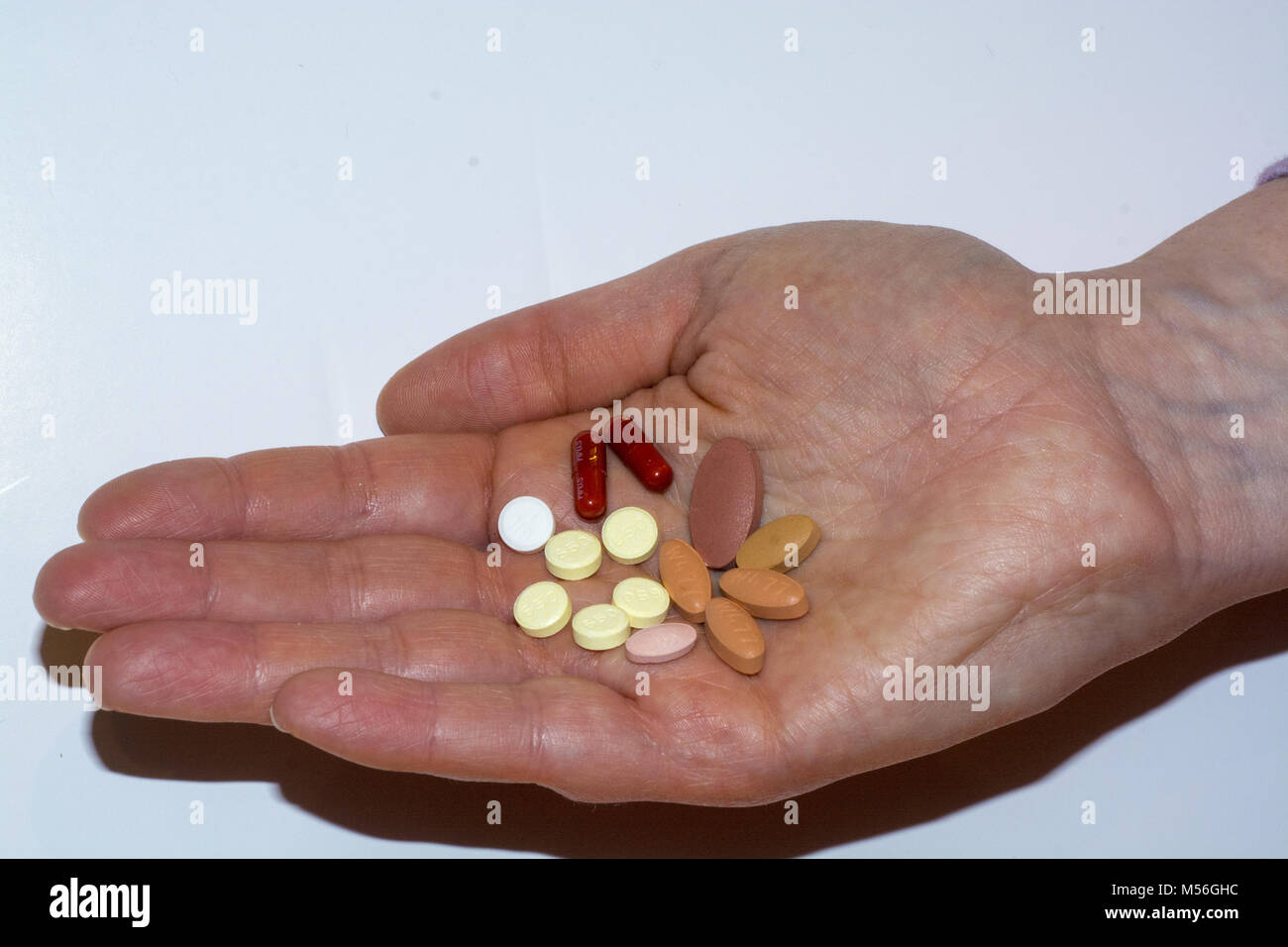 A number of tablets used to treat Parkinson's disease in the palm of someone's hand Stock Photo