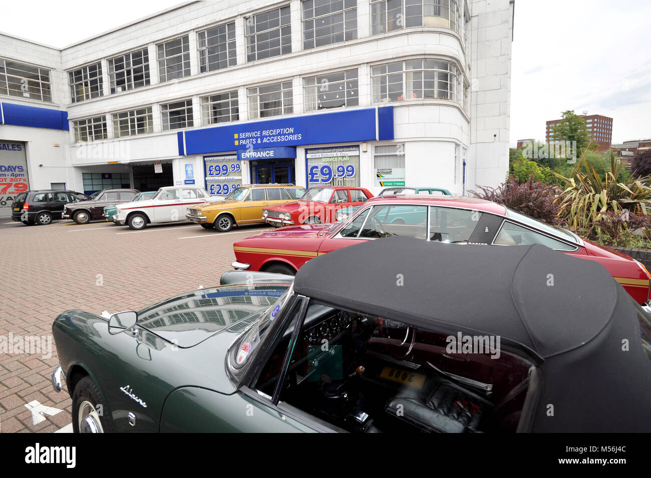Meeting of classic Hillman and Singer Rootes Group cars at the old Maidstone factory, the art deco building is now a Peugeot car dealership Stock Photo