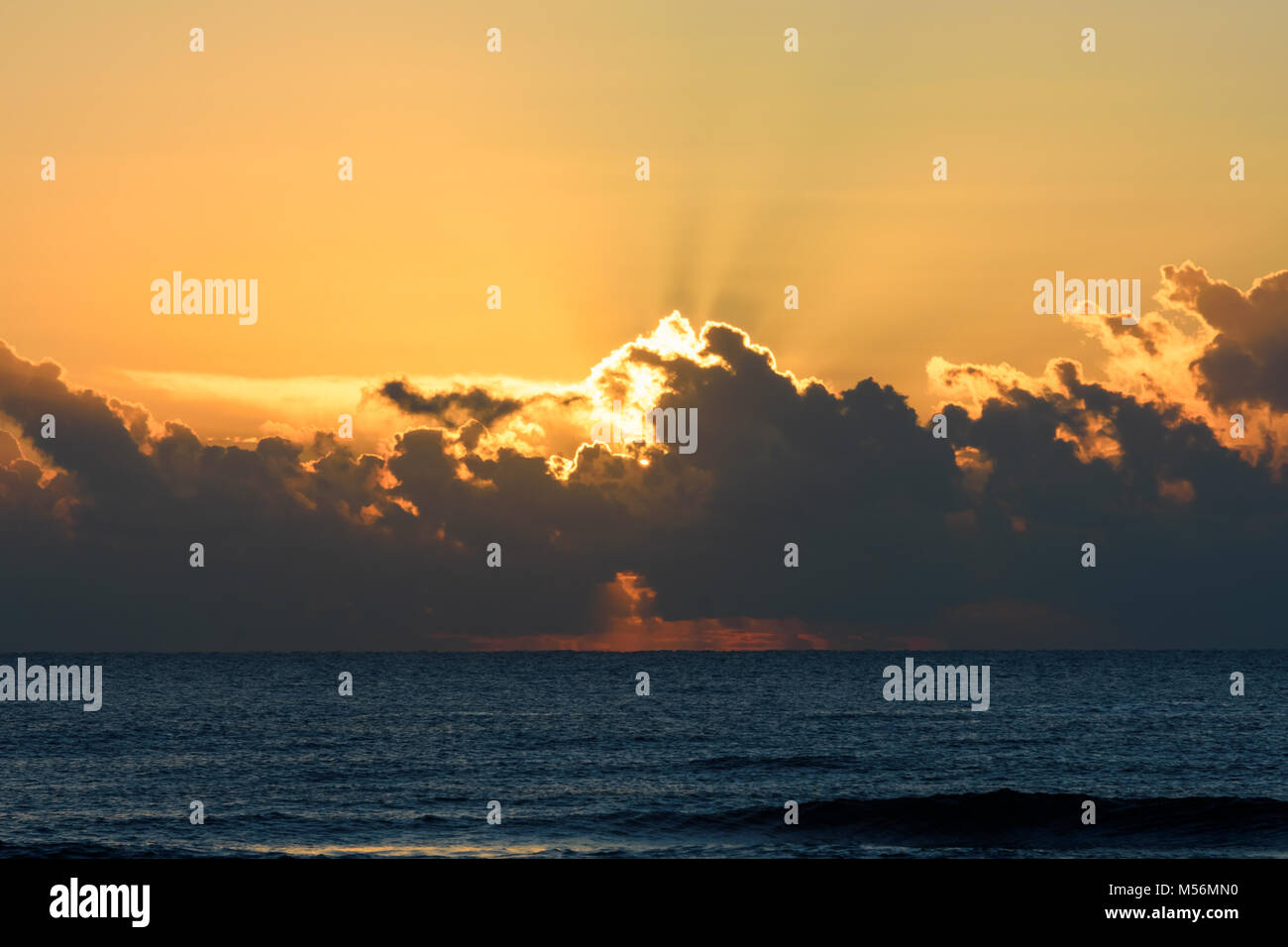 Golden sunrise or sunset over the sea. Rays of the sun shining through ...