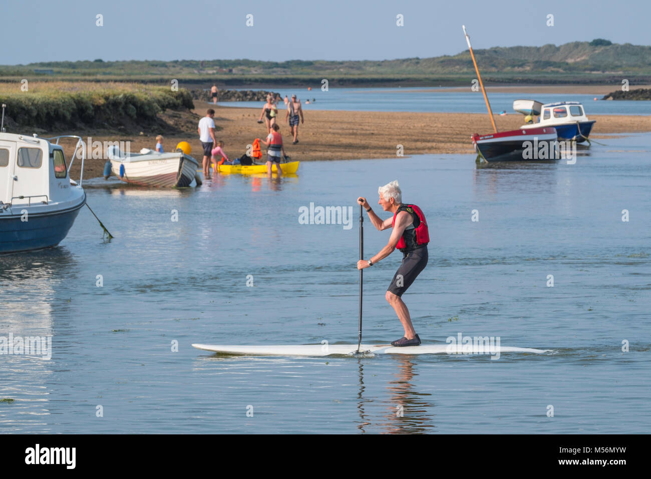 A Paddle boarder, swimmers and boaters enjoying fine weather. Stock Photo